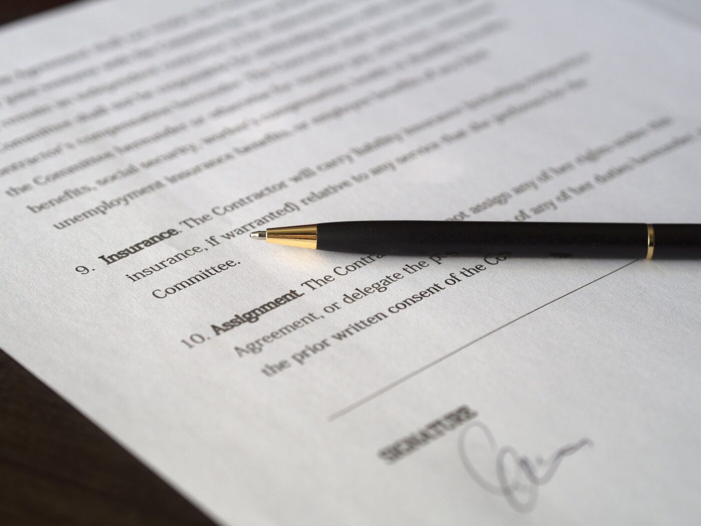 A contract being signed with a fountain pen